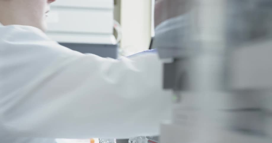 A scientist is grabbing equipment in a lab
