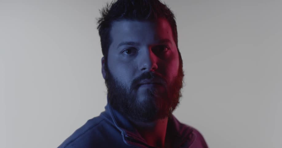 A man stands in front of a white backdrop