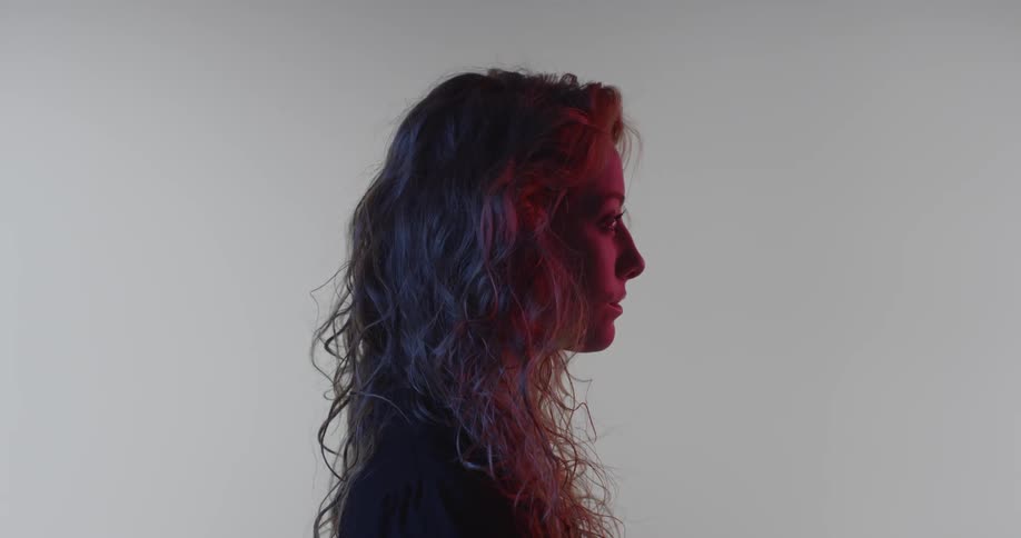 A woman is standing and staring straight ahead