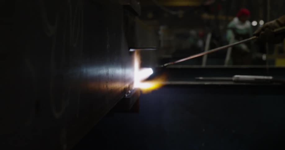 A welder uses a torch on a steel beam