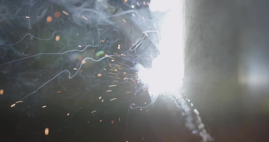 Person welding as the sparks fly all around