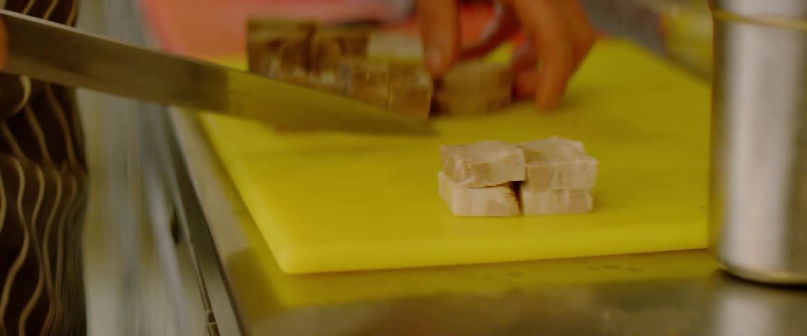 A chef cuts food into squares