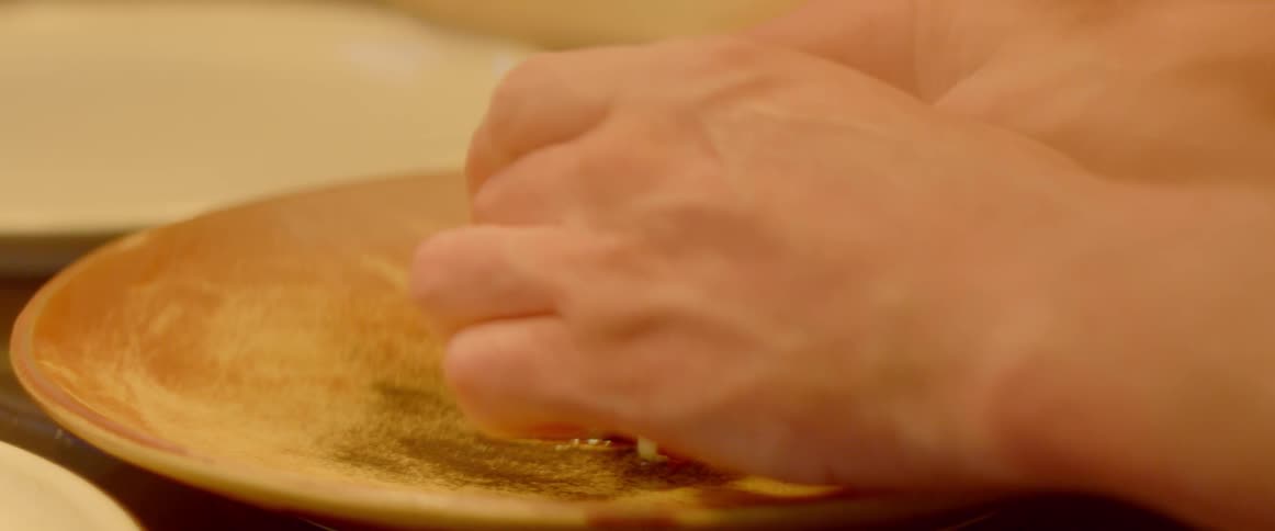 A chef plates food in the kitchen