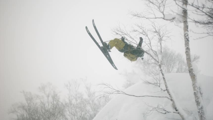 A skier does a flip and jumps into the air
