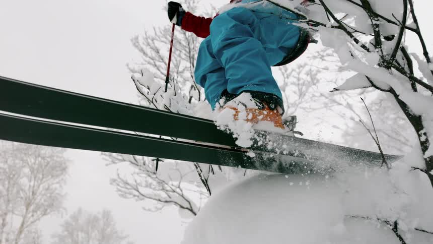 A skier launches off a snowy jump