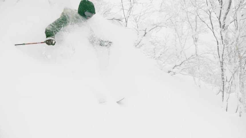 Person skiing down a hill with snow swirling around