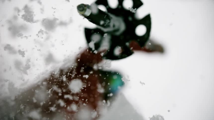 Person lifts ski pole out of snow