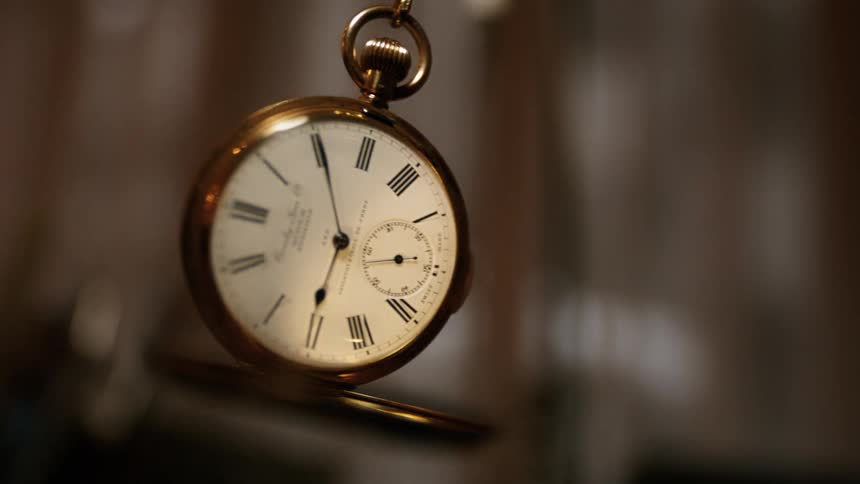 A pocket watch swings in the air in extreme slow motion