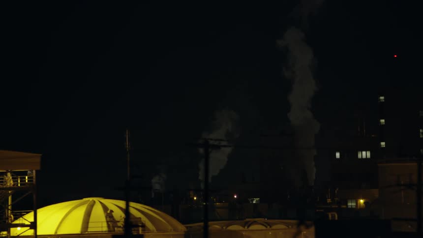 A large city with a busy street is filmed at night
