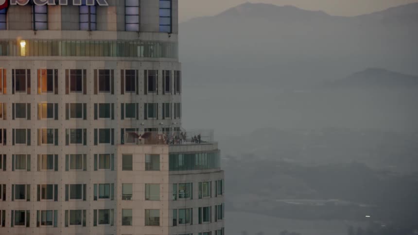 The sun is setting behind the tall buildings