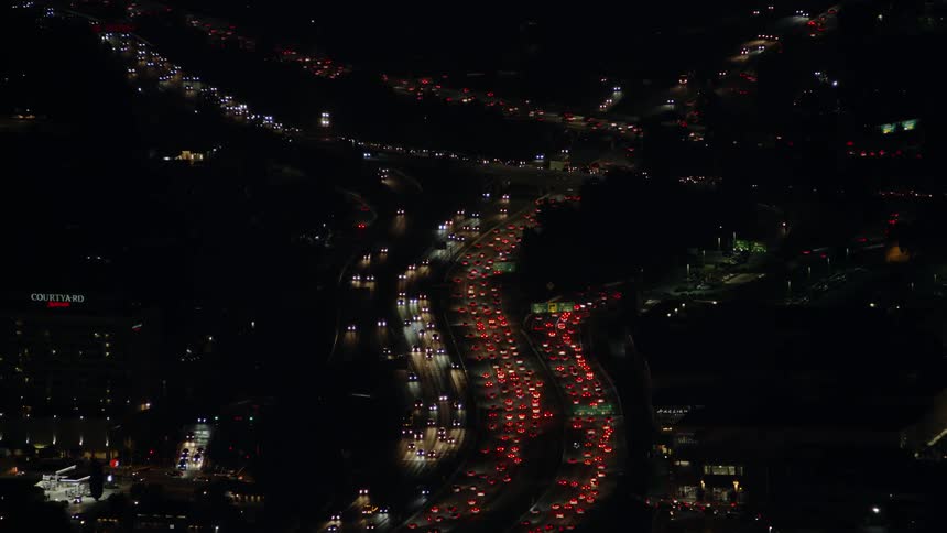 People and cars travel in the city below at night