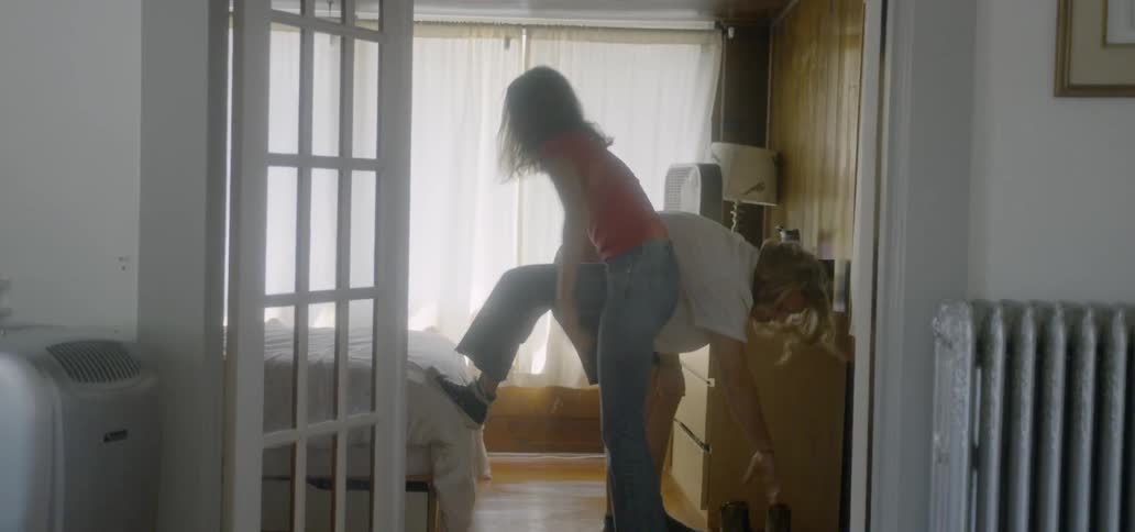 A man and woman get dressed in the bedroom and walk out