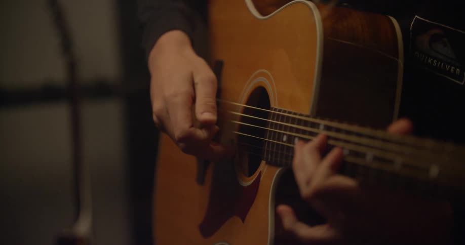 A guitarist plays an acoustic guitar