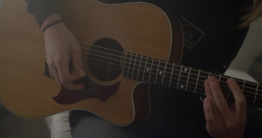 A man plays an acoustic guitar
