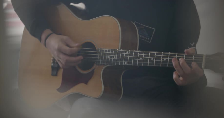 Person plays an acoustic guitar