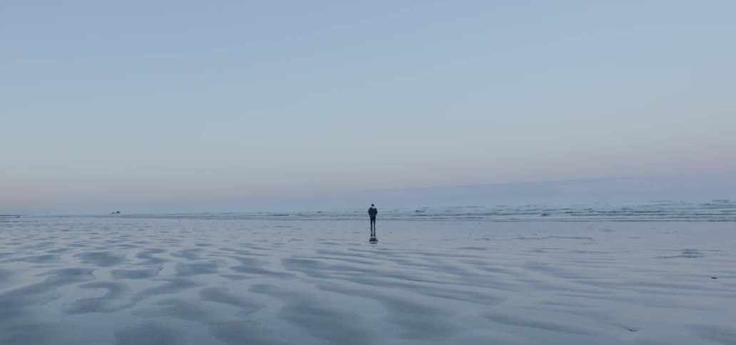 A man walks on the beach shore