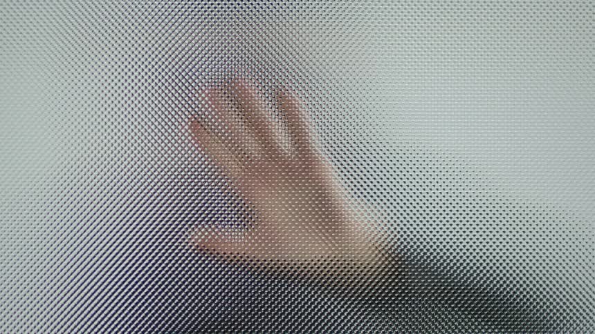 Person places hand on glass and slides it