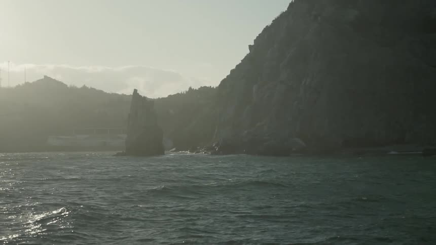 Ocean water flows around the base of a cliff