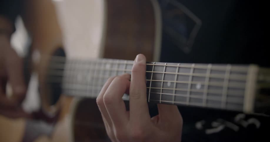 A man plays an acoustic guitar
