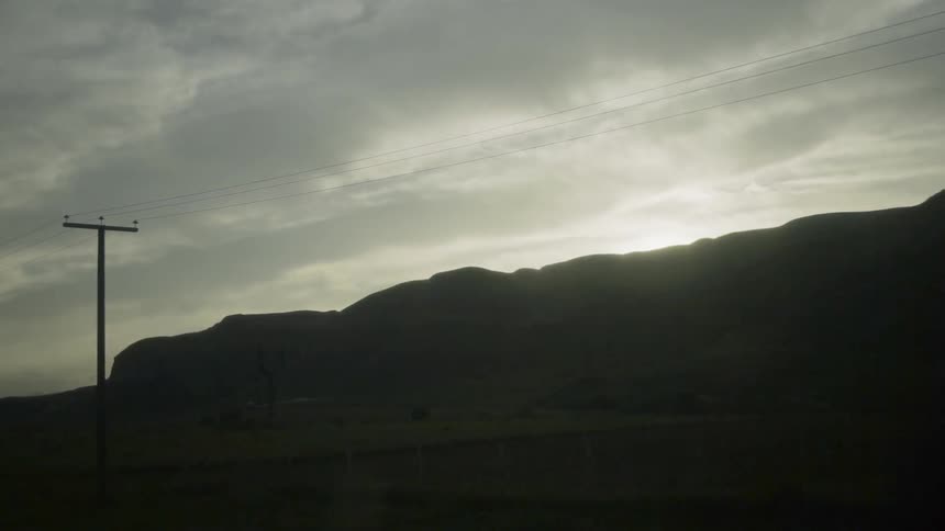 Power poles stand tall on the side of the road
