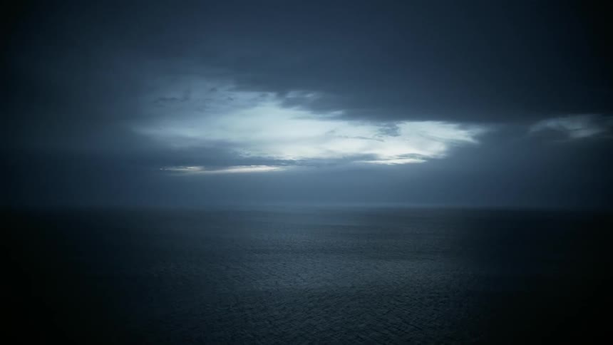 Clouds hang above the ocean waters