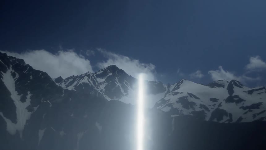 Sun reflecting over snowy mountains
