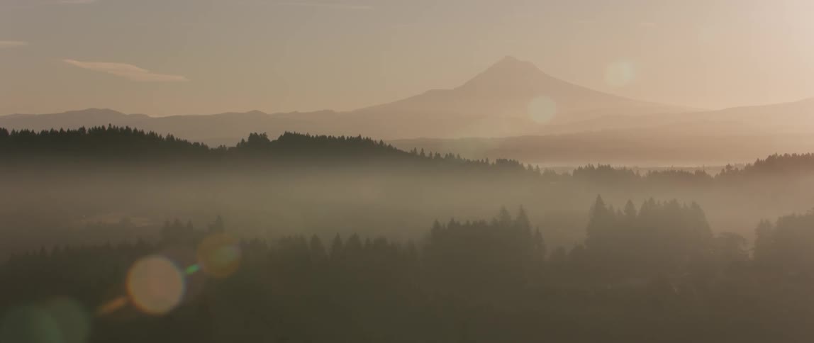 Fog floats over a mountain valley at sunset