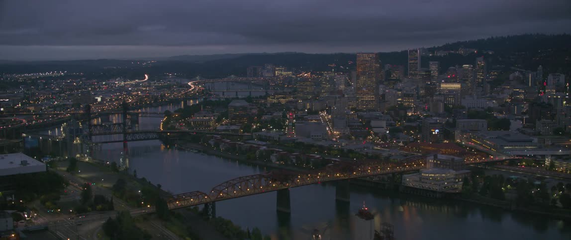 City buildings and bridges are lit up at night