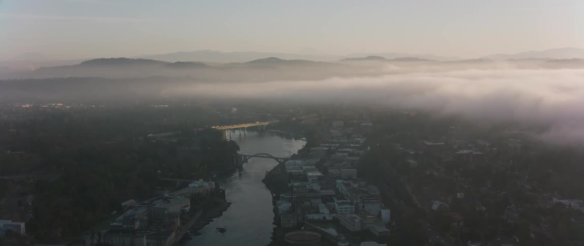Mist floats over a city river