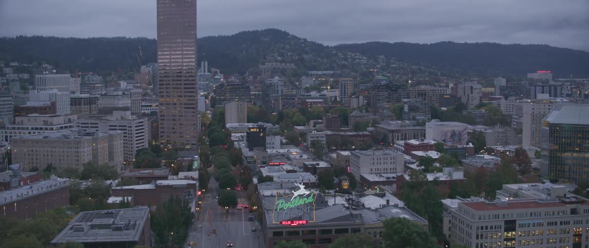 Traffic is flowing on a street in downtown portland, oregon at dusk