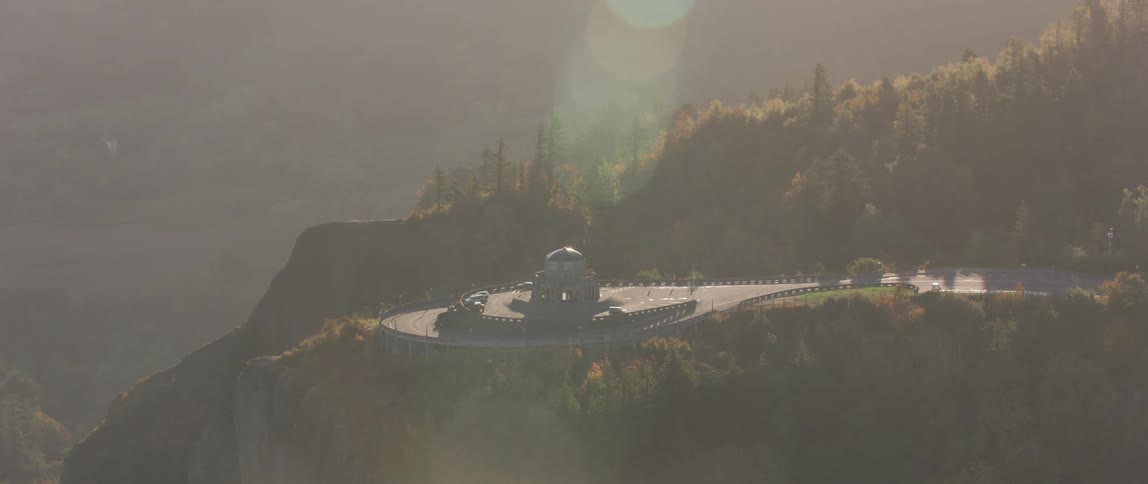 The sun shines on building atop a mountain