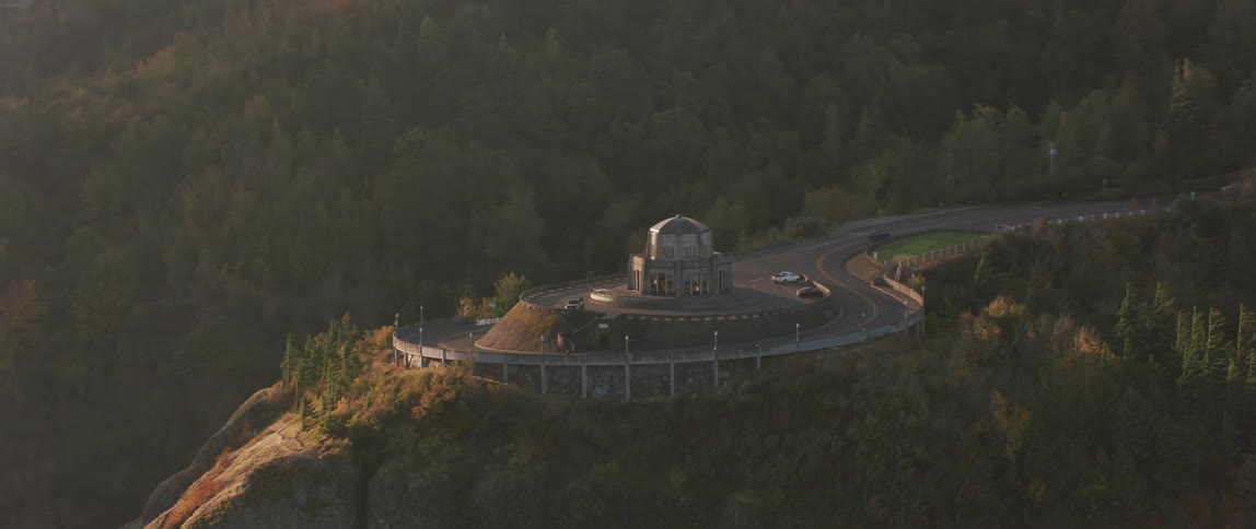 A building sits on a roundabout on a mountain road