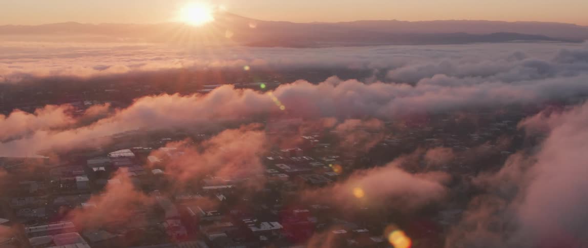 The sun shines brightly through clouds