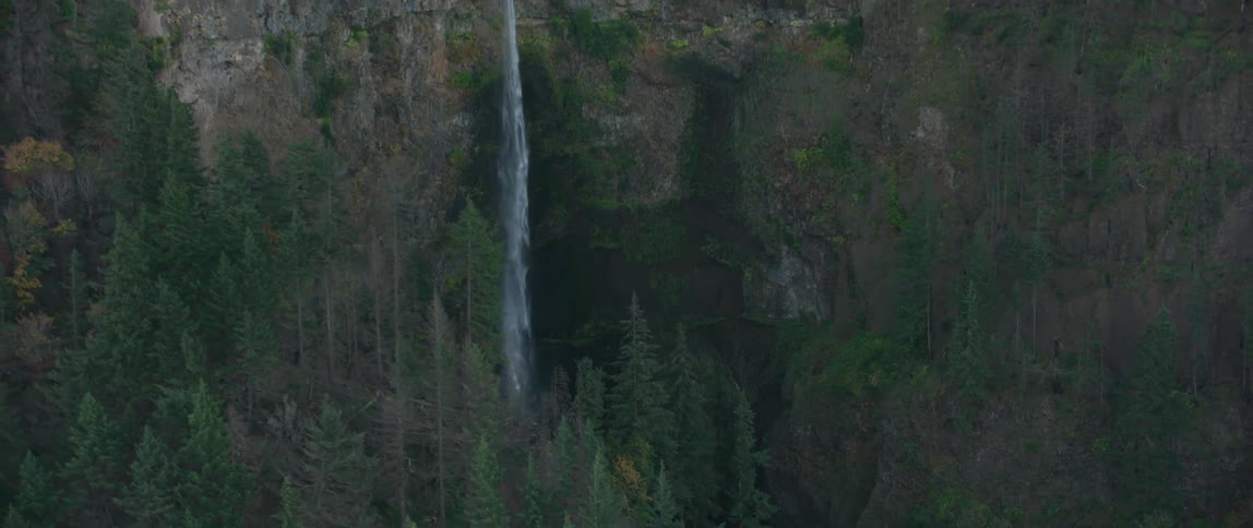 A stream plunges over a rock cliff in the mountains