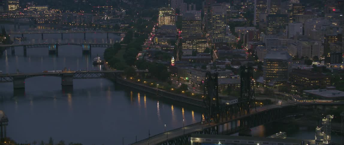 Buildings lit up at night next to a river