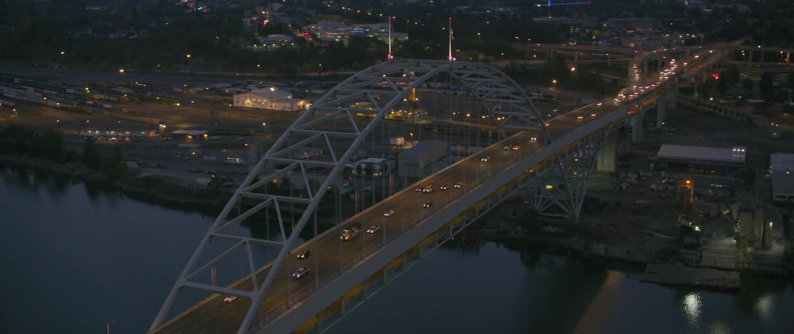 Vehicles cross a city bridge at night