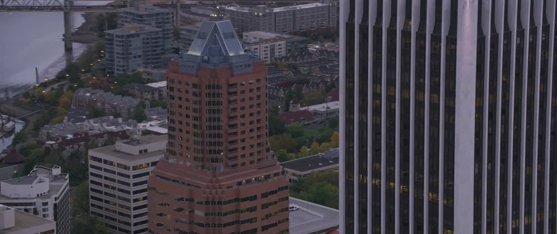 The skyscraper windows reflect the city and lights around them