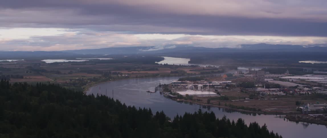 River flows through an industrial area on a cloudy day