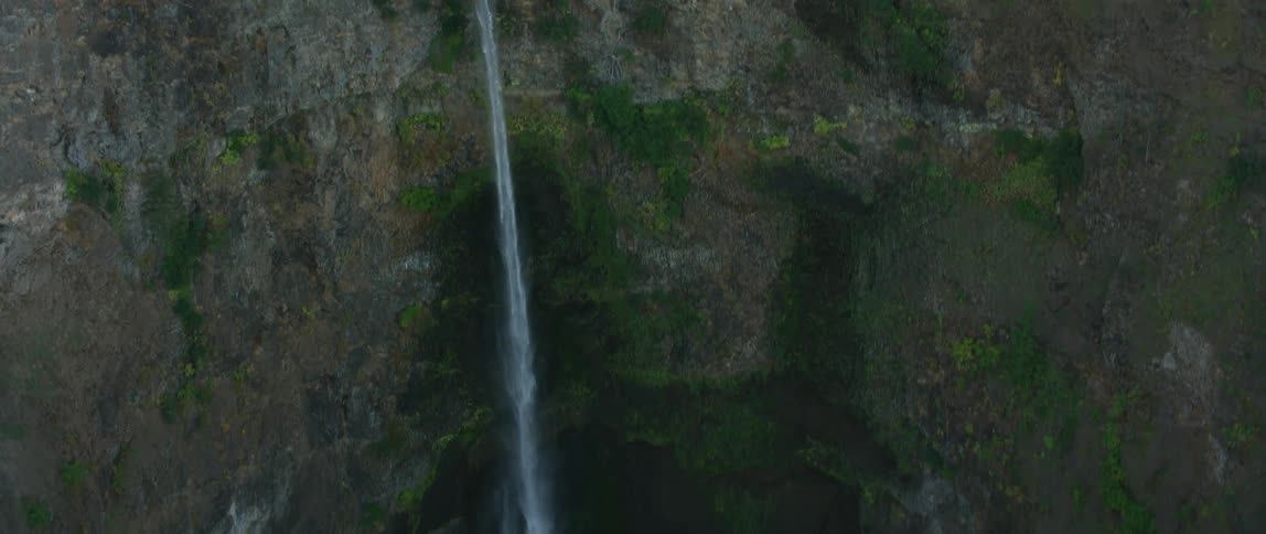 Water pours out of the side of a cliff