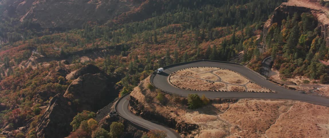 Vehicle sitting high on a road made as a lookout near cliffs