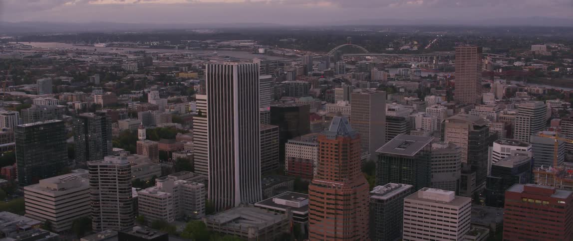 A large city with a body of water on a cloudy evening