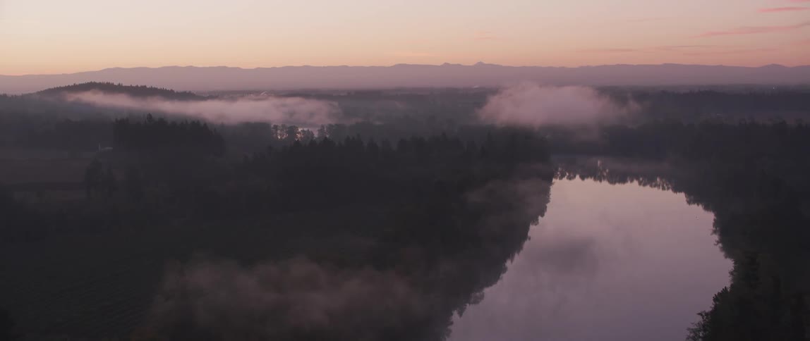 Fog and haze lift above the river