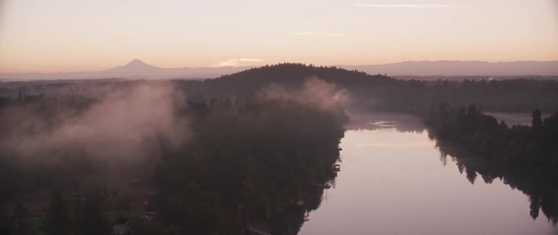 Haze lifts from the river as the sun rises