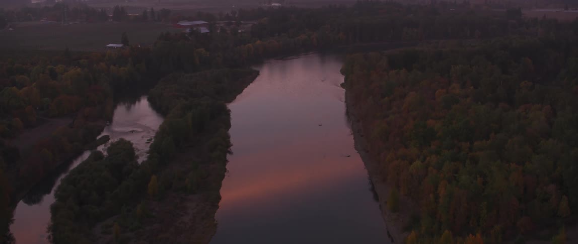 The sun sets over a rural river