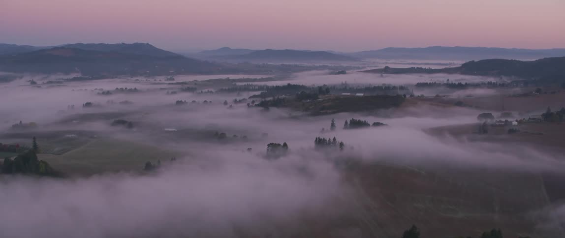 Fog and haze lift above a mountain valley