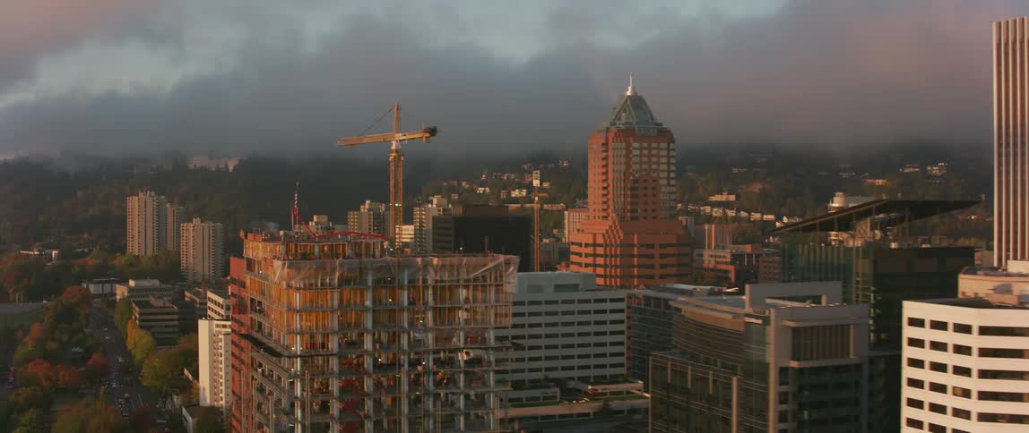 Sunlight hits the city skyscrapers as clouds gather