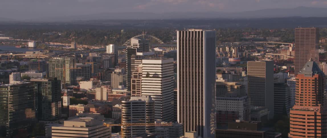 The sun shines on city skyscrapers and roof tops