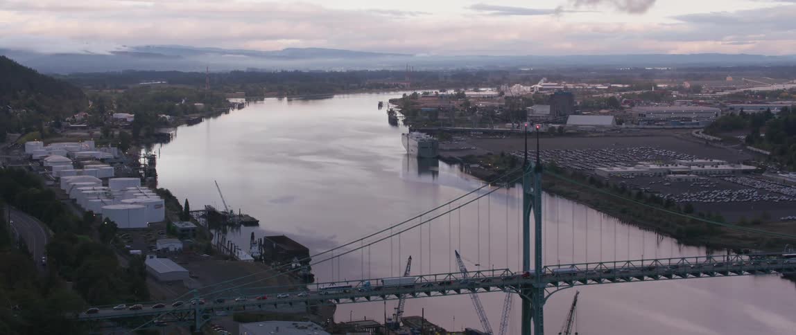 A river is flowing through an industrial area in an urban setting on a cloudy day