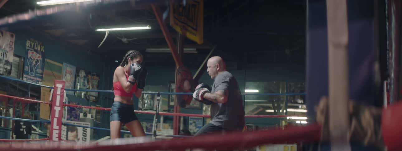 A boxer trains in the ring with a coach