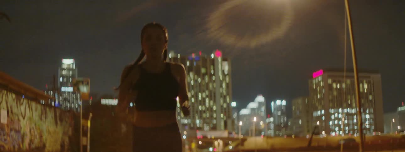 A woman is running in the city at night